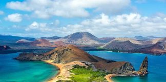 Volcanic island with twin turquoise bays and rocky pinnacle