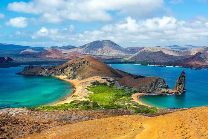Volcanic island with twin turquoise bays and rocky pinnacle