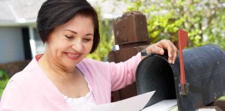 Woman checking mail at a roadside mailbox