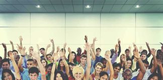 Texas Just Changed What Students Learn About Islam Group of people raising hands in an indoor audience