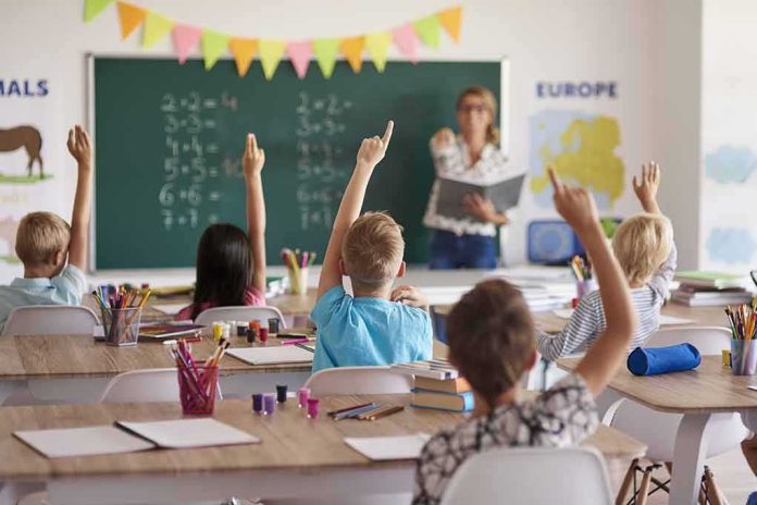 shutterstock_466453328 Students raise hands in classroom during lesson