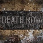 Rusty metal sign on worn concrete wall