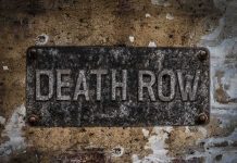 Rusty metal sign on worn concrete wall