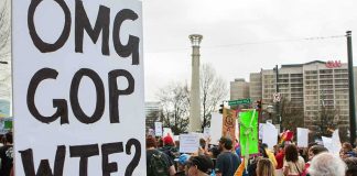 Protesters holding signs at a city street demonstration