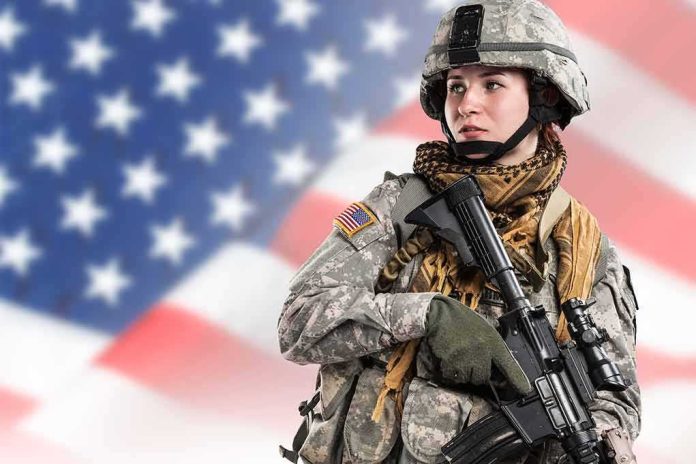 shutterstock_679646599 Soldier in camouflage holding a rifle against a blurred American flag