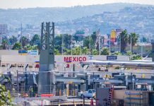Border crossing booths at Mexico entry point with cityscape in background