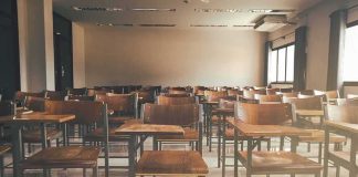 School Ends SECRET Gender Policy Empty classroom with rows of wooden desks and chairs
