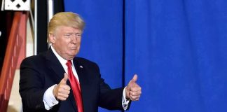 Trump Pardons 2 Mechanics Donald Trump giving two thumbs up in front of a blue curtain