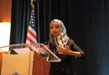 Ilhan Omar speaking at a podium with a microphone