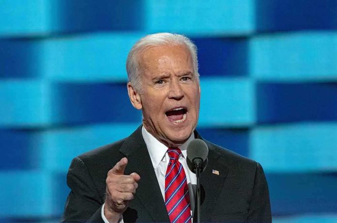 shutterstock_1362500381 Joe Biden speaking at a podium with a microphone, gesturing with his finger