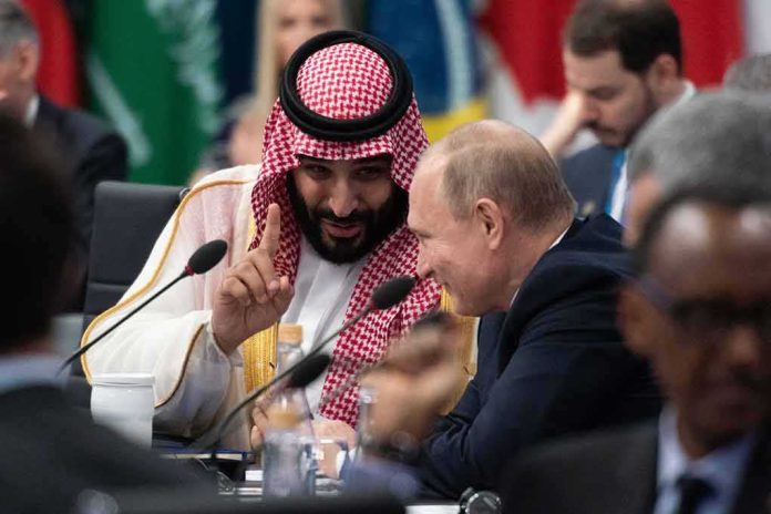 Mohammad bin Salman gestures while speaking with Vladimir Putin at a conference table