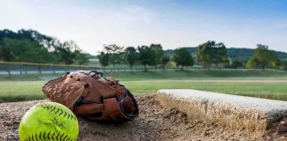 Parents BRAWL at 12-Year-Old Girls’ Softball Game Softball and glove near a base on a dirt field