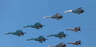 Germany Is REARMING and Sending Troops East A formation of military jet fighters flying in a clear blue sky