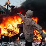 40,000 Rioters Hit Paris Streets Hooded person throws object near street fire