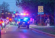 Emergency vehicles with flashing lights on a city street at night