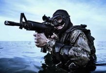 Combat diver aiming rifle in open water