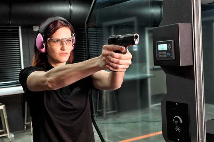 shutterstock_605965226 Woman aiming a handgun at an indoor shooting range