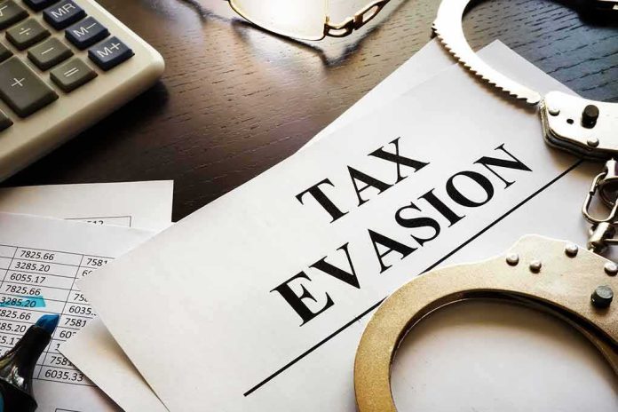 Handcuffs and calculator on tax evasion document